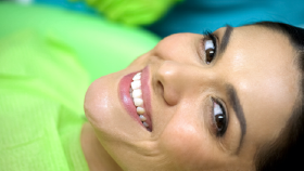 A woman smiling while at the dentist’s office