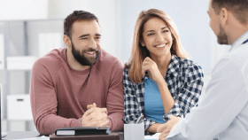 A couple smiling and talking with their medical professional