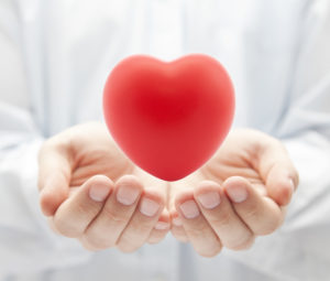 woman holding heart in palm 