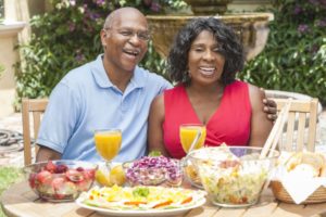 couple with dental implants in Burleson enjoying assorted summer foods 