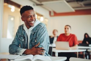 Student sitting in a classroom and smiling.