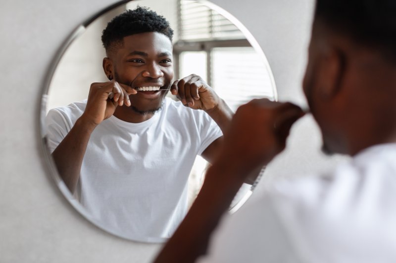 A man flossing for his New Year's resolution