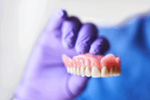 a close-up of a dentist holding dentures